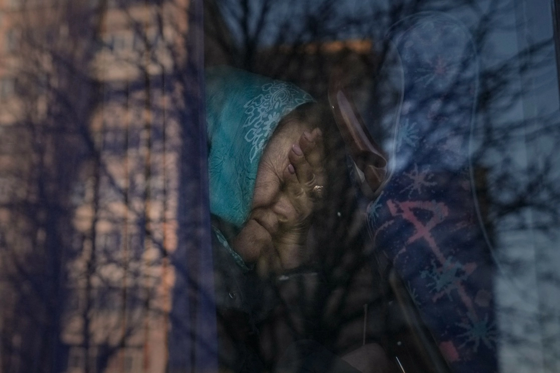 Una refugiada llora mientras el autobús en el que es evacuada permanece detenido en un puesto de control en Brovary, en las cercanías de Kiev, el 20 de marzo de 2022. Foto Ap