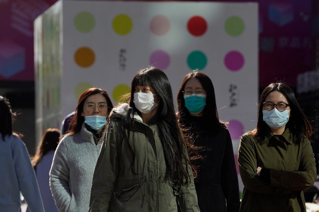 Residentes chinas usan máscaras en vía pública en Pekín. La mayoría de las personas en esta  capital todavía usan cubrebocas en zonas al aire libre, incluso cuando China ha controlado en gran medida el brote. Foto AP