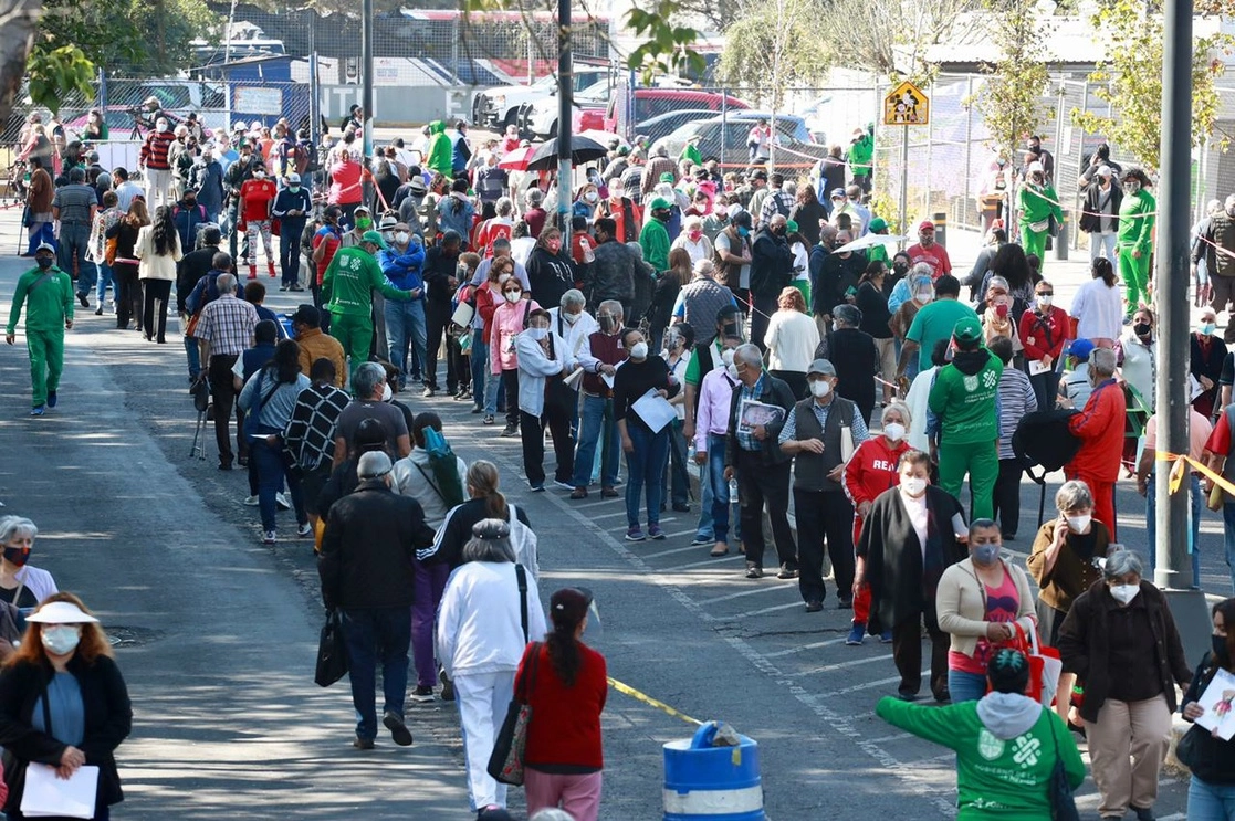 Adultos mayores hacen fila afuera de la Escuela Superior de Educación Física, donde recibirán la vacuna contra Covid-19, en la alcaldía Iztacalco, Ciudad de México, el 25 de febrero de 2021. Foto Luis Castillo