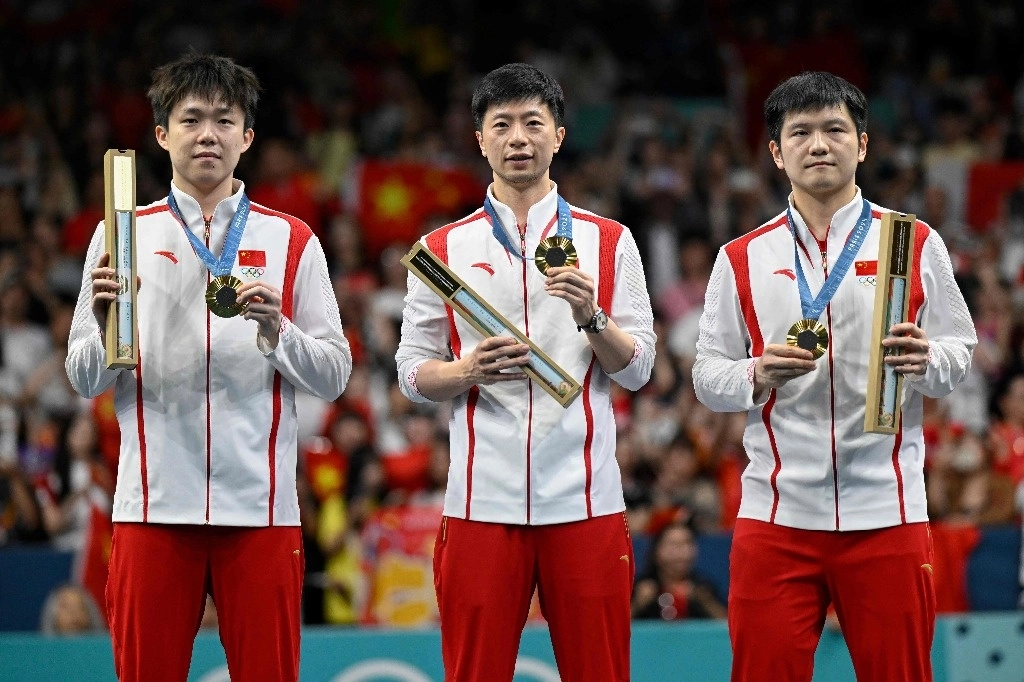 Los medallistas de oro Wang Chuqin de China, Ma Long de China y Fan Zhendong de China posan con sus medallas en el podio del evento por equipos de tenis de mesa masculino en los Juegos Olímpicos de París 2024 en el South Paris Arena de París el 9 de agosto de 2024. Foto Afp