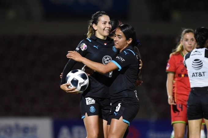 La jugadora de Chivas, Alicia Fernández (c,izq) festeja su anotación durante el encuentro. Foto tomada de la cuenta de Twitter @ChivasFemenil