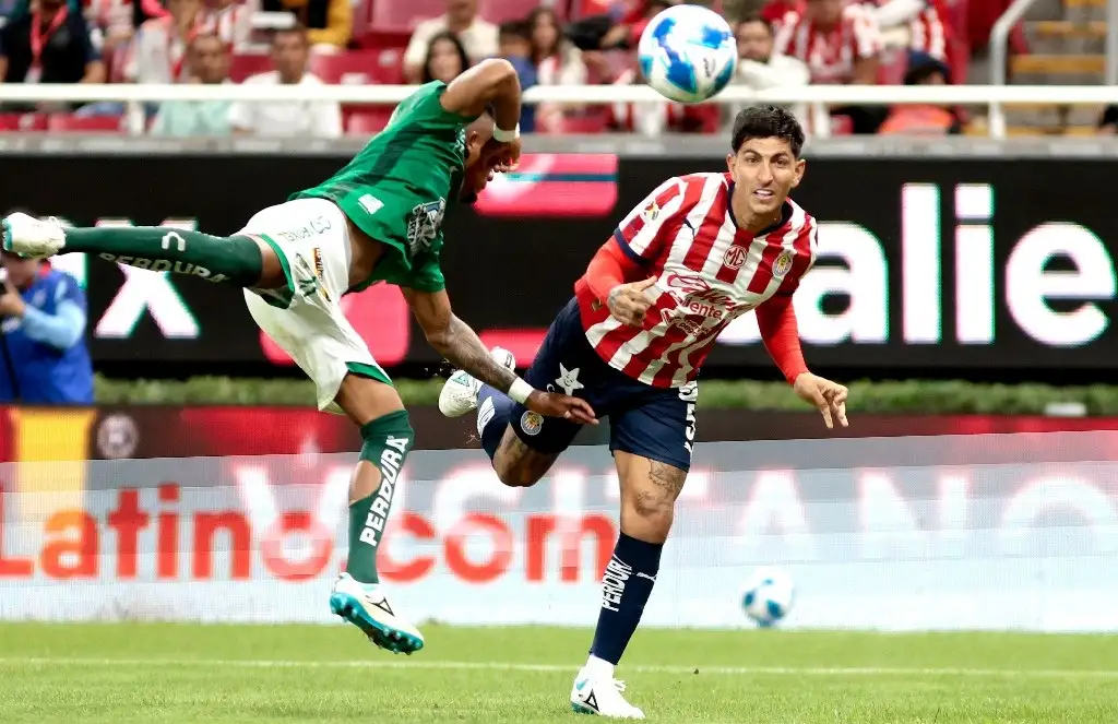 El mediocampista argentino de León, Luciano Cabral (izq.), y el mediocampista de Guadalajara, Víctor Guzmán, luchan por el balón durante el partido de fútbol del torneo Apertura de la Liga MX entre Guadalajara y León en el Estadio Akron en Zapopan, estado de Jalisco, México, el 18 de septiembre de 2024. Foto Afp