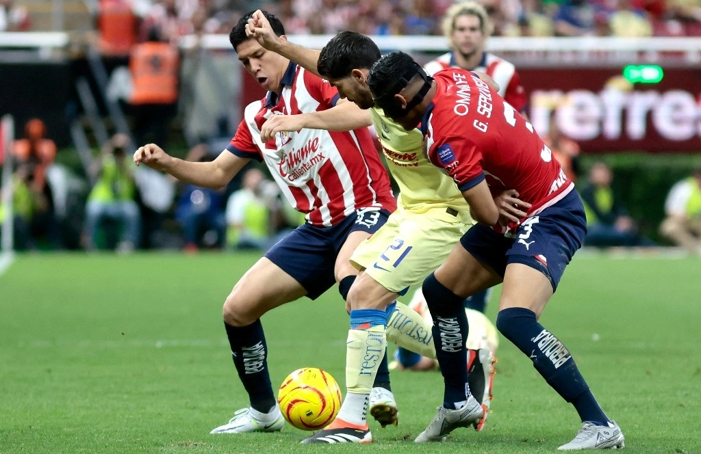Jesús Orozco y Gilberto Sepúlveda de Guadalajara luchan por el balón con Henry Martin del América. Foto Afp