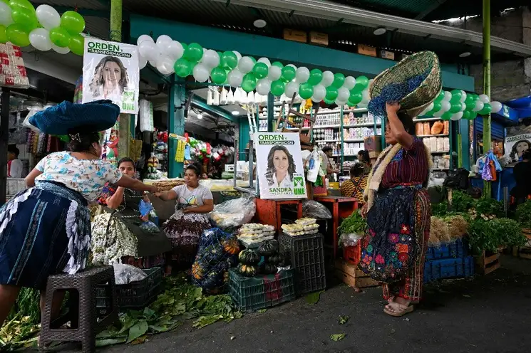 Carteles con la imagen de Sandra Torres, candidata de la Unidad Nacional de la Esperanza, en un mercado de la ciudad de Guatemala. Foto Afp.