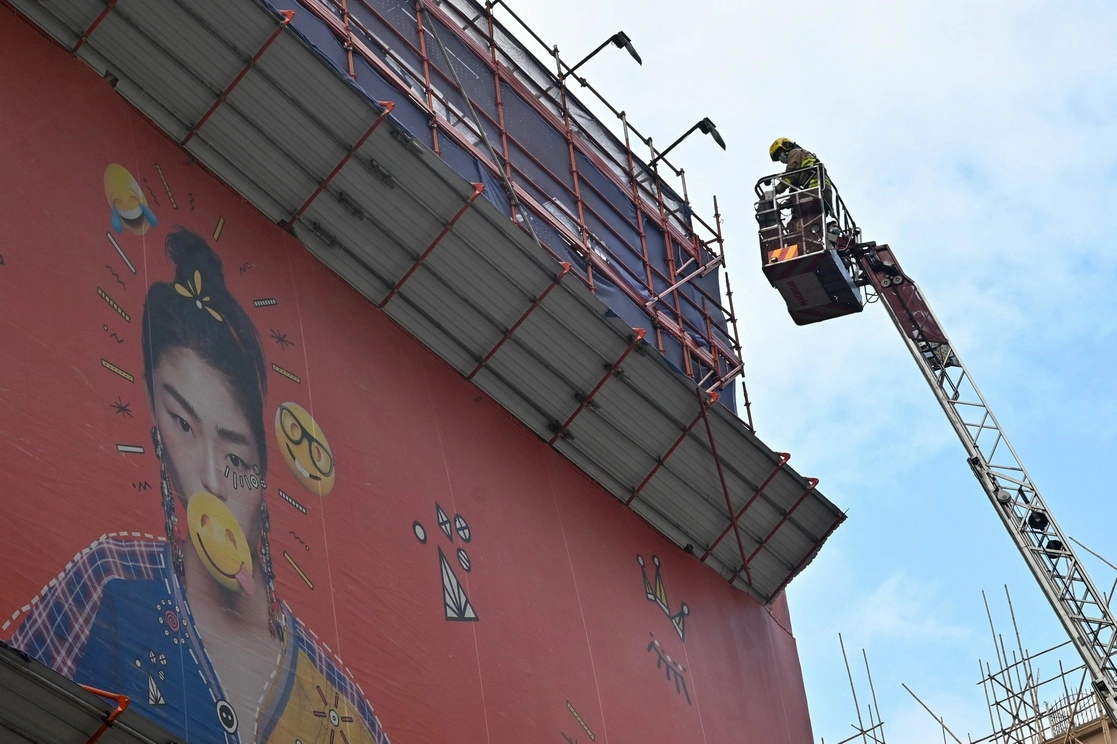 Un bombero participa en la operación de rescate de cientos de personas atrapadas por un incendio en el techo de un rascacielos de 38 pisos en Hong Kong, el 15 de diciembre de 2021. Foto Afp 