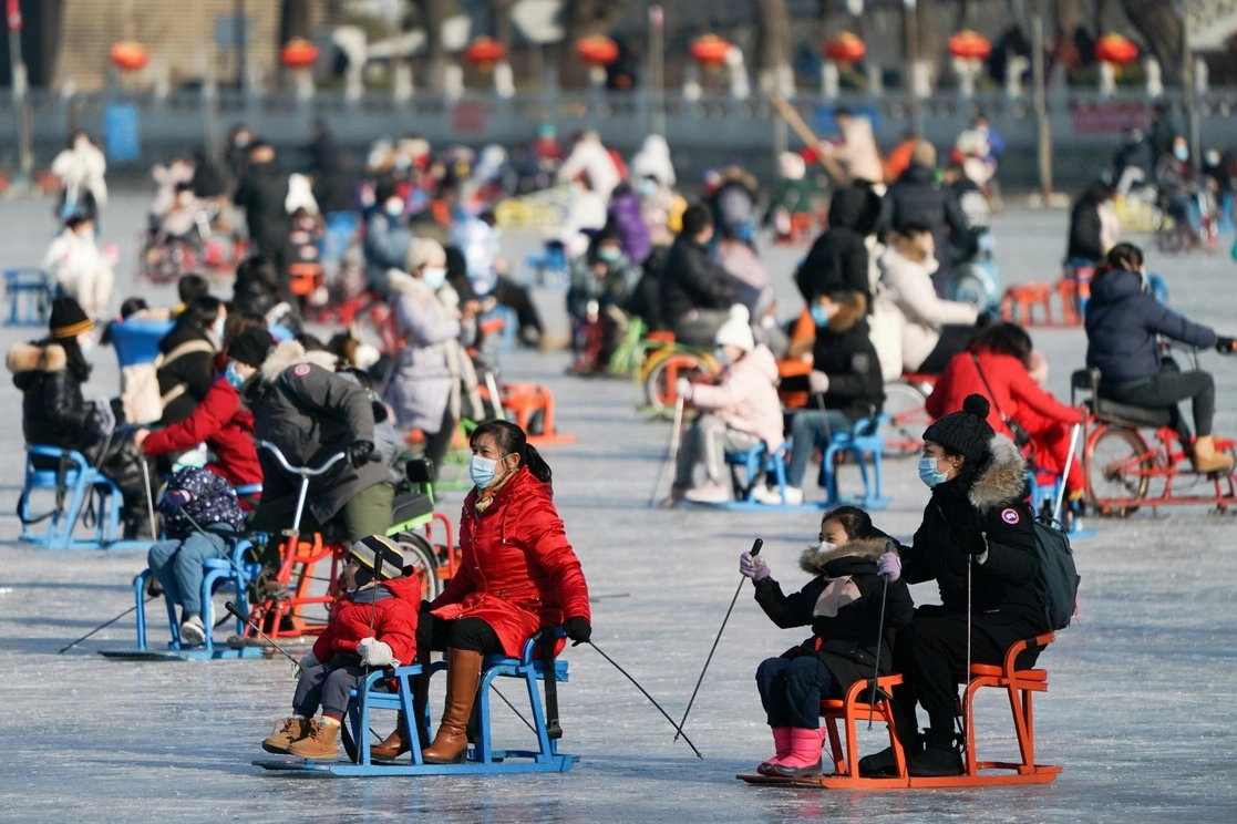 Personas juegan sobre el lago Shichahai cubierto de hielo que se ha convertido en una pista de hielo, en Beijing. Foto Xinhua