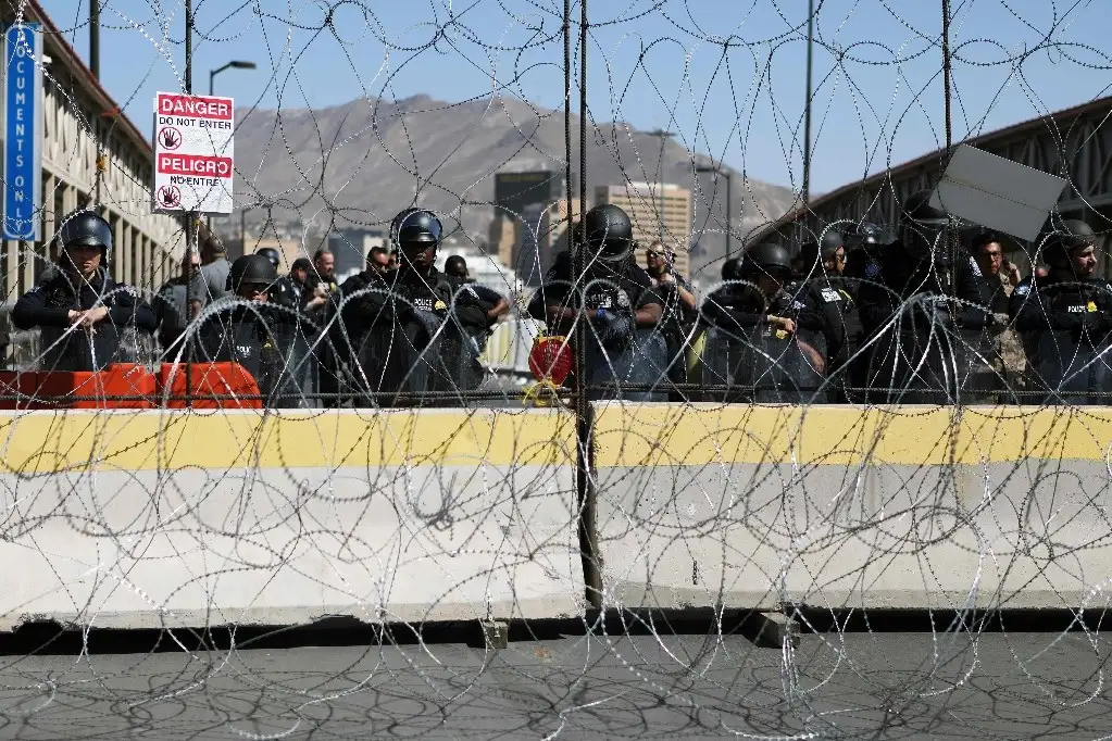 Agentes de Aduanas y Protección Fronteriza estadunidenses instalaron una barricada a la mitad del puente internacional para retener a la multitud en Ciudad Juárez, Chihuahua. Foto Afp