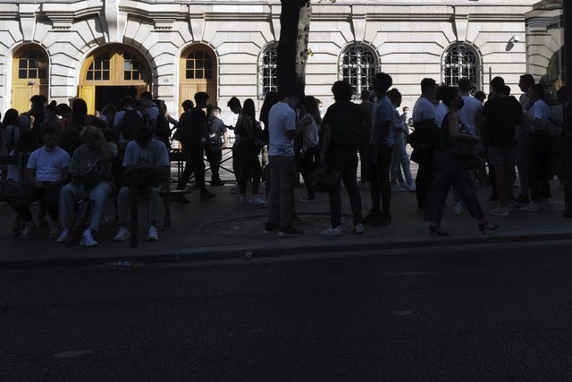 Estudiantes, algunos con cubrebocas, se reúnen afuera de una escuela en París, en medio de una alza de casos de coronavirus en Francia. Foto Ap 