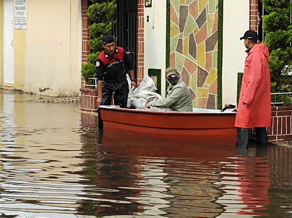 En el municipio mexiquense de Ixtapaluca, bomberos emplean lanchas para trasladar a personas que quedaron atrapadas en sus viviendas debido a la acumulación de agua, el 13 de mayo de 2021. Foto ‘La Jornada’
