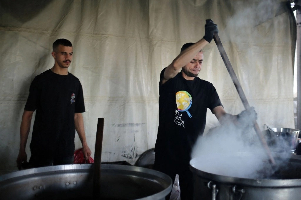 Voluntarios de la ONG World Central Kitchen preparan alimentos para los palestinos asentados en Rafah, al sur de la franja de Gaza. Foto Afp
