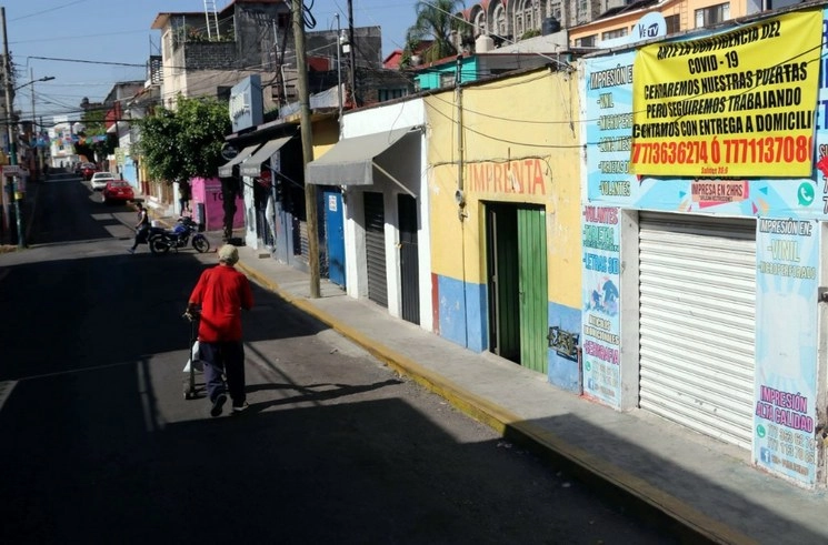 Una persona de la tercera edad camina en una calle desierta del barrio de Amatitlán, en Cuernavaca, Morelos, donde se nota un descenso en la actividad pública, el 27 de marzo de 2020. Foto Cuartoscuro