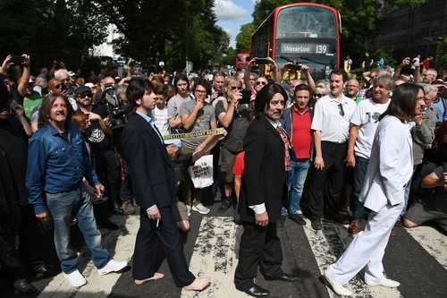 En imagen de archivo, una banda imitadora de los Beatles cruza la famosa cebra peatonal ubicada frente a los famosos estudios Abbey Road. Foto Afp