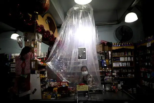 Una cajera de un supermercado atiende a los clientes detrás de una cortina de plástico en Buenos Aires, Argentina. Foto Ap 