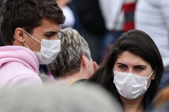 Turistas usan mascarillas para evitar contagios de coronavirus, durante el rezo del Angelus del Papa en la Plaza de San Pedro del Vaticano. Foto Afp