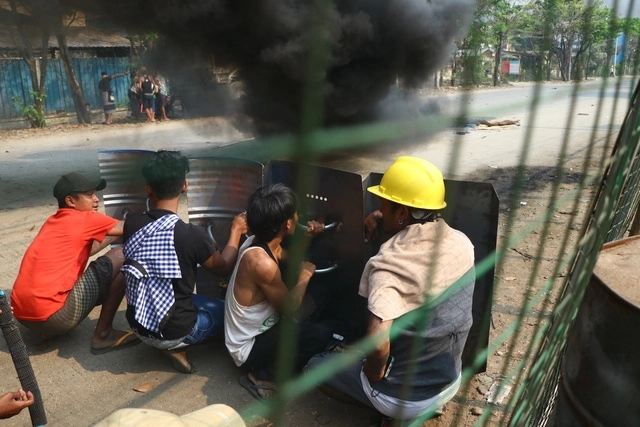Manifestantes antigolpistas se protegen con escudos de proyectiles lanzados por la policía y los militares en 
 la ciudad de Yangón. Foto Ap