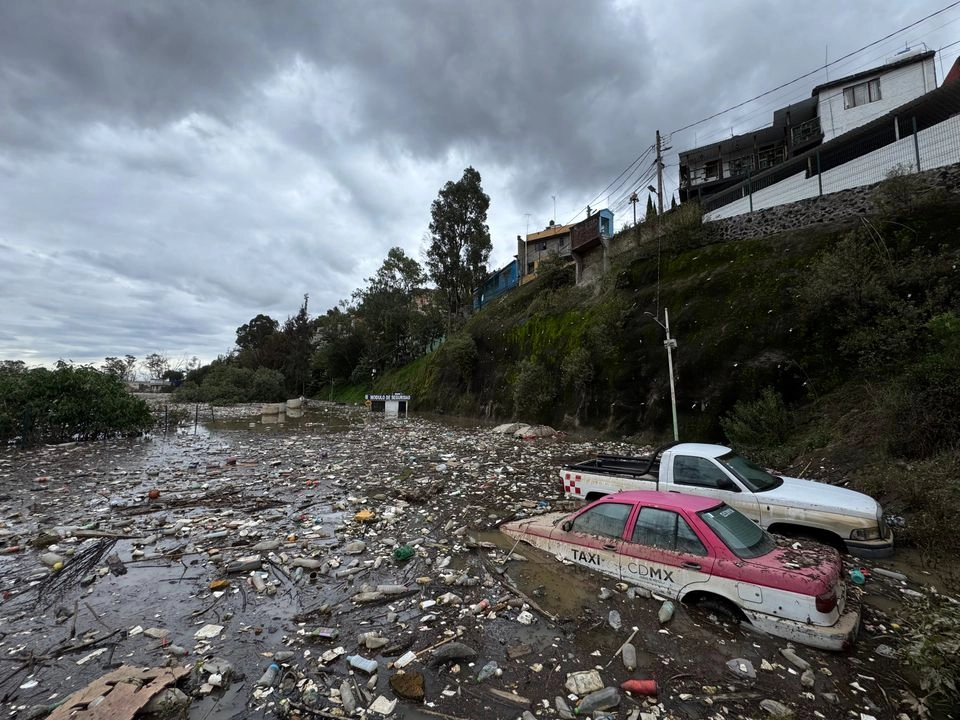 Vehículos quedaron atrapados entre el agua y la basura luego del desbordamiento de la presa Mixcoac, ubicada en la alcaldía Álvaro Obregón, en la Ciudad de México, el 30 de junio de 2025. Foto 