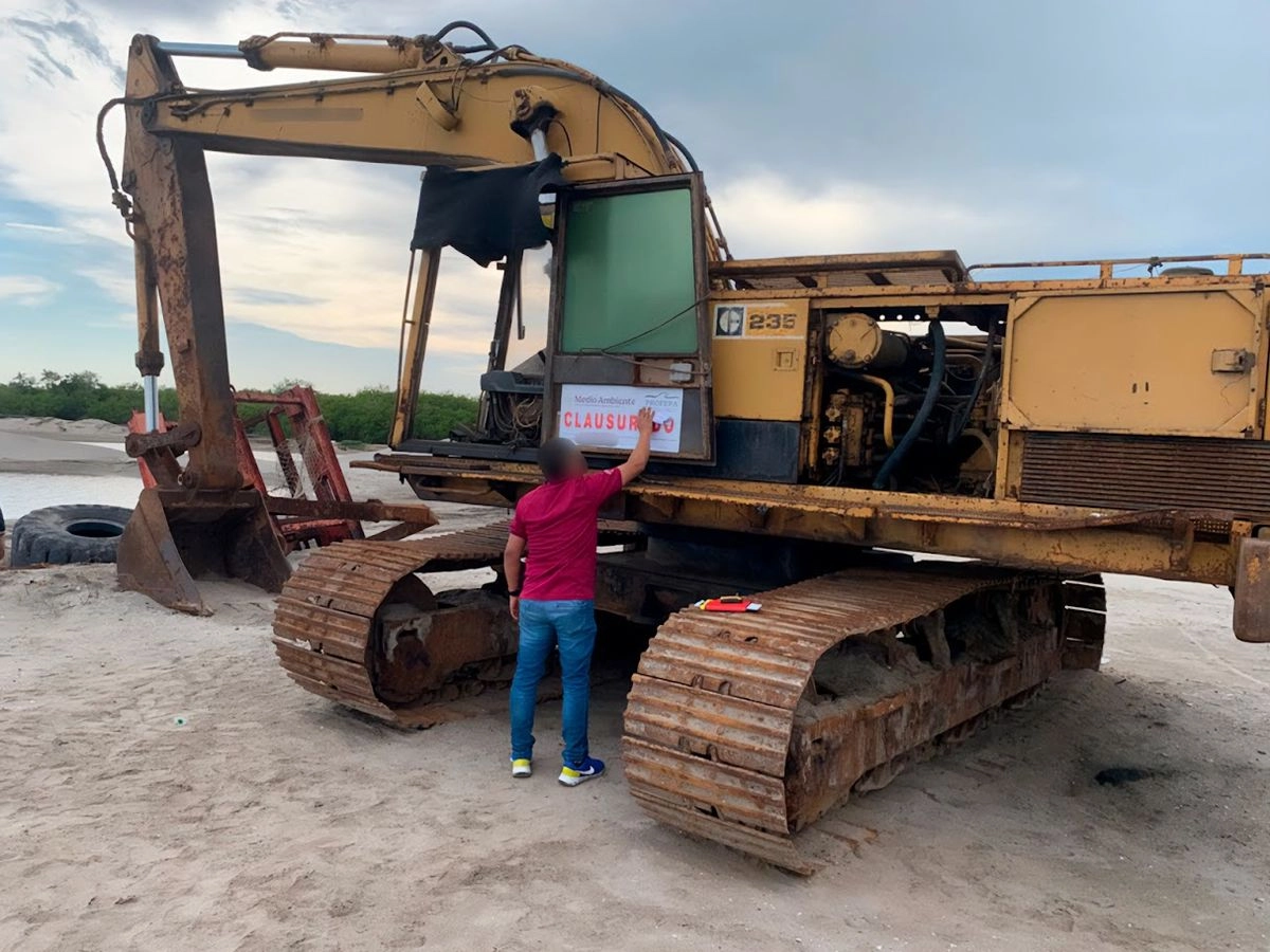 Un inspector ambiental coloca una etiqueta de clausura a una retroexcavadora utilizada en la construcción del fraccionamiento Lotes Exclusivos Manglares. Foto 
