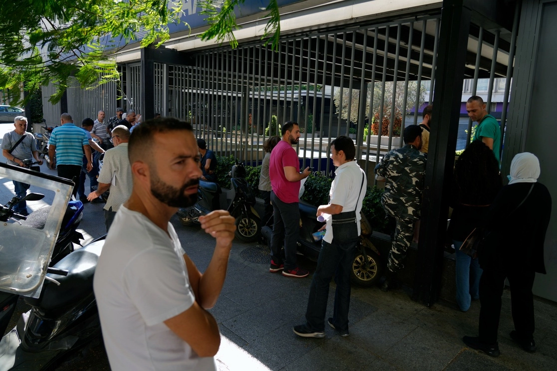 Personas esperando afuera de una sucursal de Fransabank para retirar dinero, en Beirut, Líbano. Foto Ap