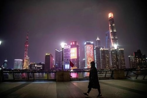 Una mujer solitaria con un cubrebocas en el malecón del Bund, generalmente repleto, en el río Huangpu, con vista al distrito financiero de Shanghái. El coronavirus que surgió en Wuhan a finales del año pasado ha matado a más de 800 personas. Foto Afp