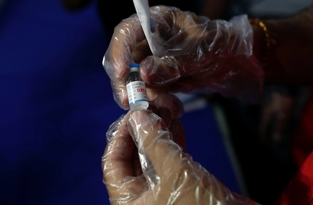 Persona sostiene una dosis de la vacuna contra Covid-19 de Sinopharm. Foto Ap