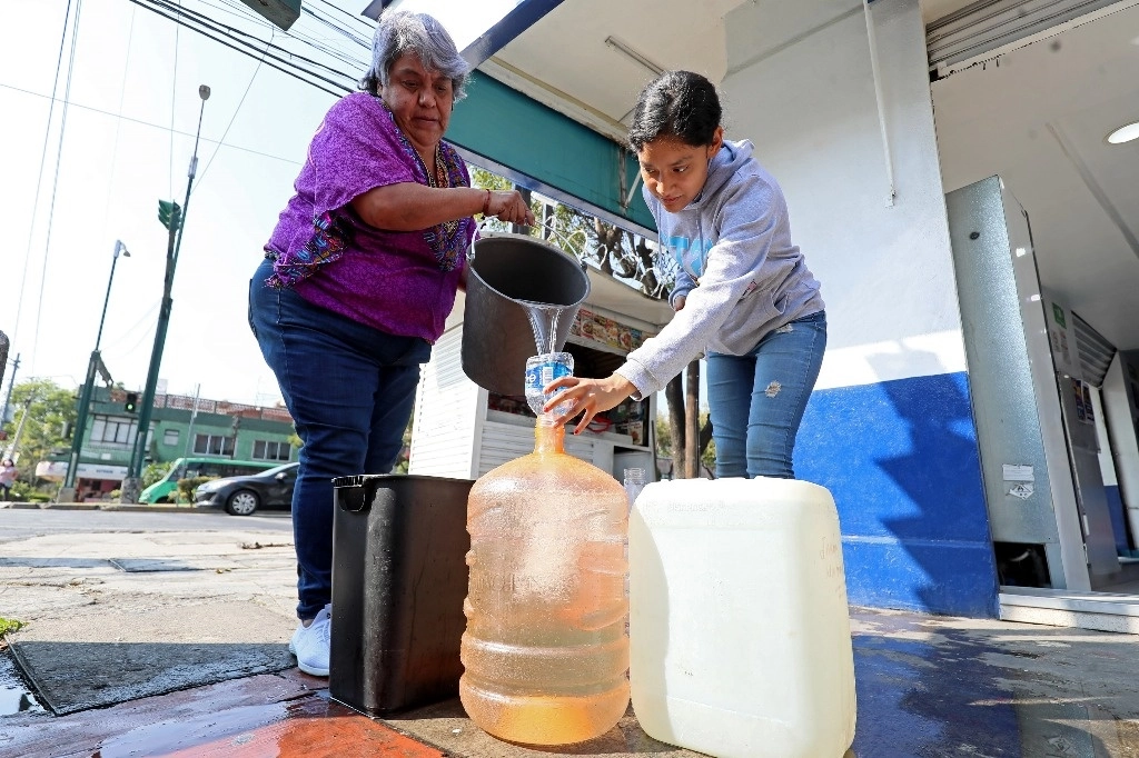Personas repartiendo agua de pipas debido a la escasez. Foto Roberto García Ortiz/ archivo