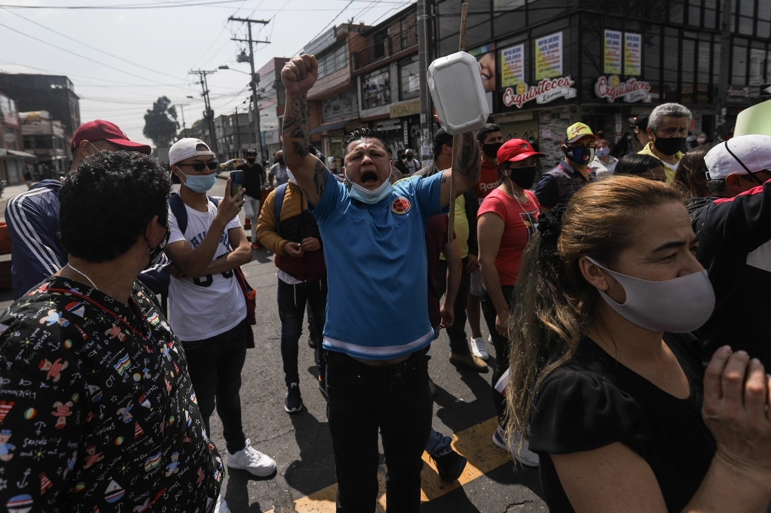Personas participan en una manifestación de comerciantes en contra de una nueva cuarentena impuesta por la Alcaldía de Bogotá. Foto Afp