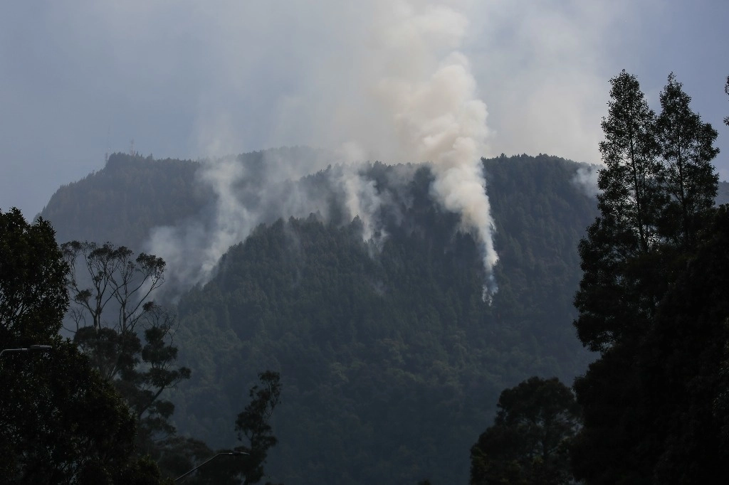 Columnas de humo de un incendio forestal en uno de los sectores en los cerros orientales, en la ciudad de Bogotá, el 26 de enero de 2024. Foto Xinhua