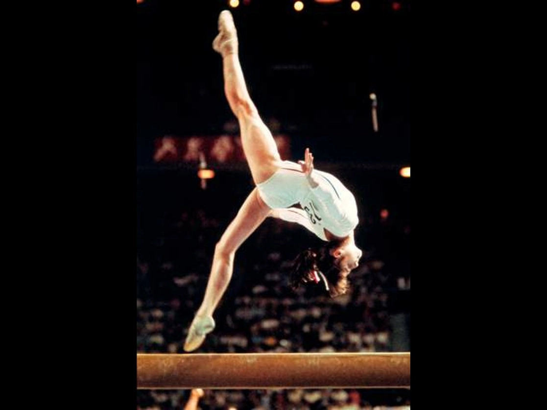 Comaneci fue la primera gimnasta en lograr la calificación máxima de 10 en Juegos Olímpicos. En la imagen de 1976 en Montreal, muestra su destreza durante su rutina en la viga. Foto Afp