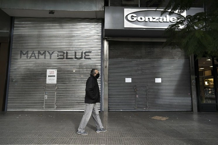 Un hombre camina frente a una zona comercial en Buenos Aires. Foto Xinhua