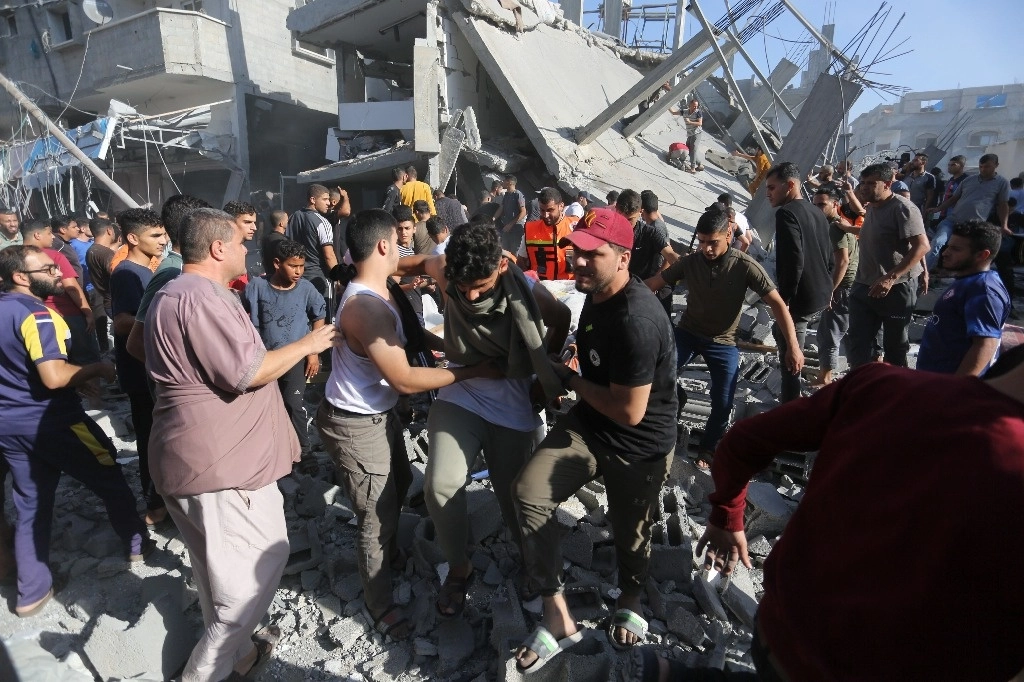 Palestinos buscan sobrevivientes tras un bombardeo aéreo en Rafah, en la franja de Gaza. Foto Ap