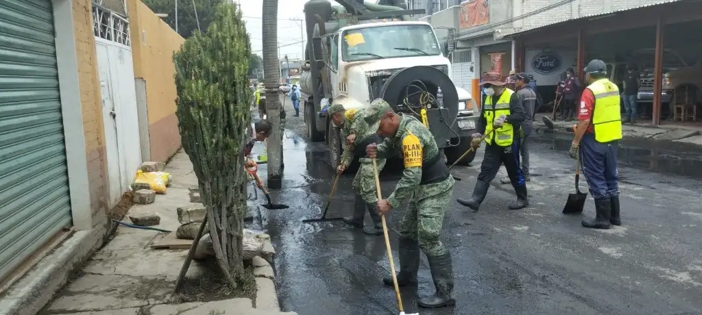 A lo largo de este sábado, recogían lodo, barrían calles, destaparon registros y coladeras de agua pluvial y desinfectaban los lugares donde ya es posible transitar; la labor, la hacían con el apoyo de empleadas del ayuntamiento de Chalco (que no los funcionarios) apoyando a la población. Foto Daniel Ramón 