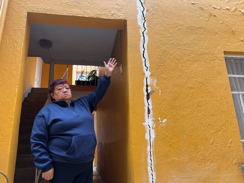 La señora Micaela muestra la grieta que cruza su departamento, la cual se originó en diciembre pasado. Foto María Luisa Severiano 