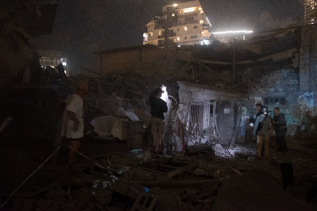 Habitantes en Tel Aviv observan los daños causados por un cohete disparado desde la Franja de Gaza, el 7 de octubre de 2023. Foto Ap