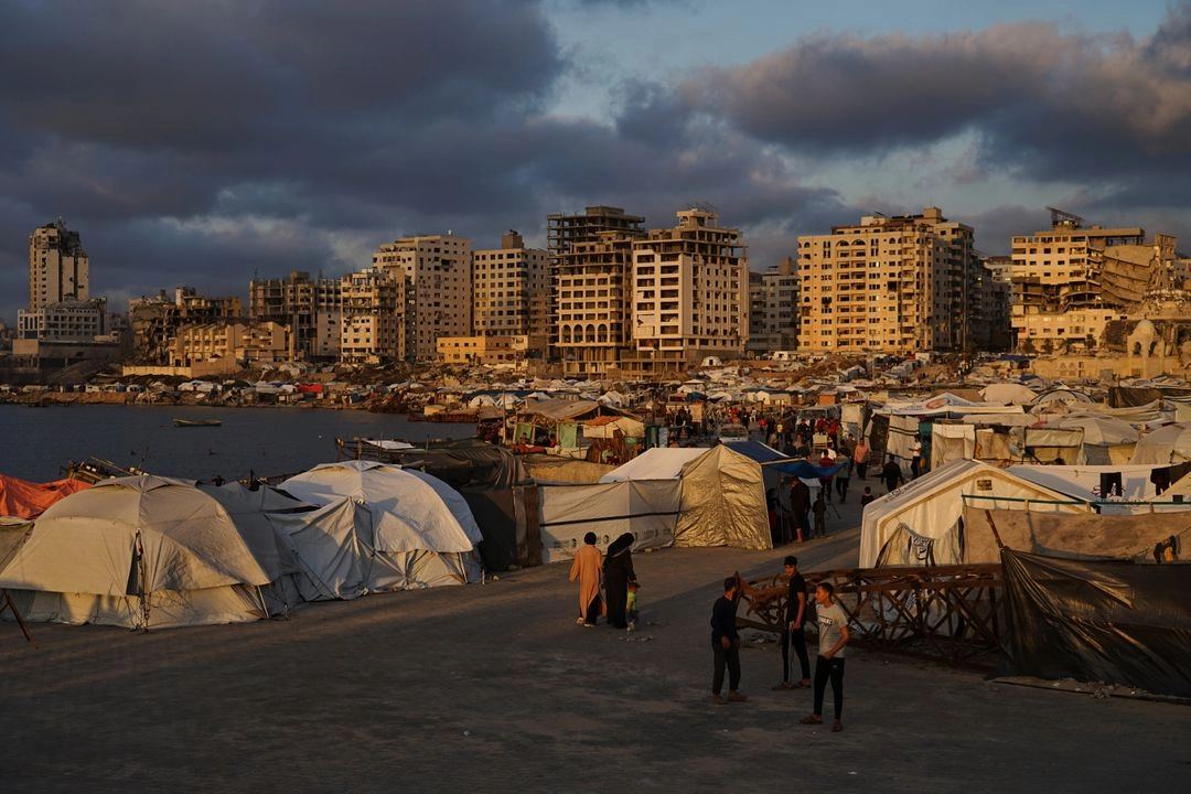 Palestinos desplazados caminan por un campamento improvisado en el puerto de la ciudad de Gaza, el jueves 22 de mayo de 2025. Foto 