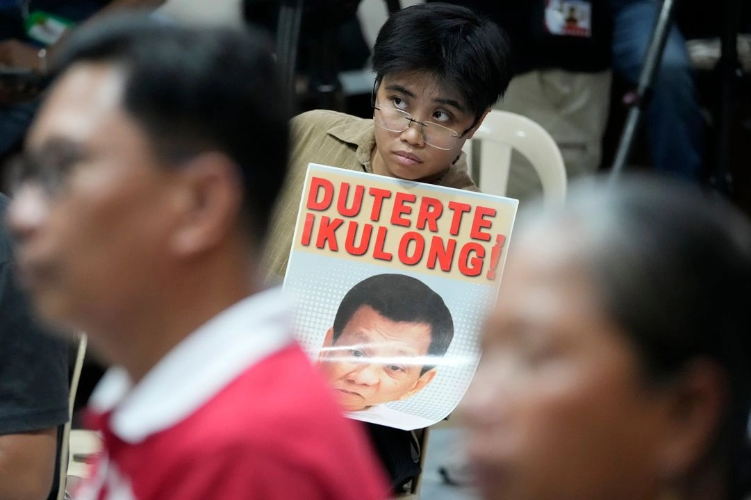 Un activista sostiene un cartel del ex presidente de Filipinas mientras mira una transmisión de la primera comparecencia ante la Corte Penal Internacional (CPI) del ex presidente Rodrigo Duterte en la ciudad de Quezón, Filipinas, el 14 de marzo de 2025. 