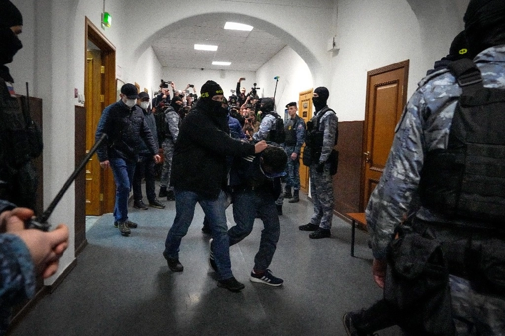 Uno de los sospechosos relacionados al atentado en una sala de conciertos en Moscú es escoltado en el Tribunal de Distrito de Basmanny. Foto Ap