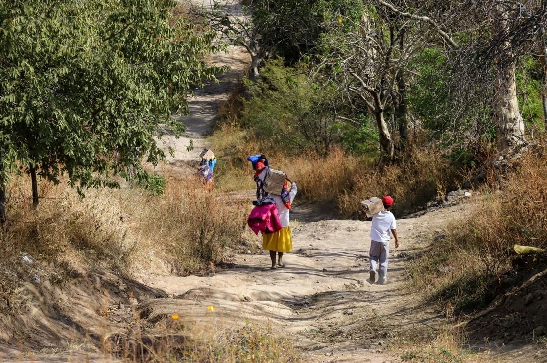 Personas cargan la ayuda del gobierno en la población de Cui taboca, Guasave. Foto 'La Jornada'