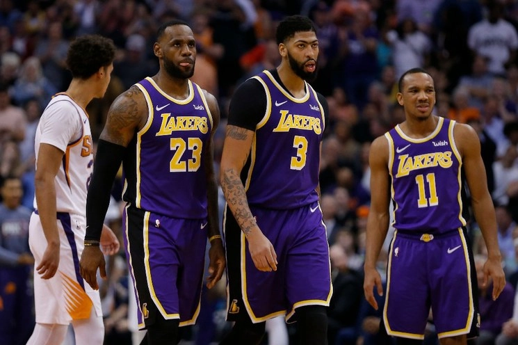 El alero de Los Ángeles Lakers, LeBron James (23) y Anthony Davis (3) observan durante la primera mitad durante un partido de baloncesto de la NBA contra los Soles de Phoenix Suns, realizado en Phoenix, el 12 de noviembre de 2019. Foto Ap