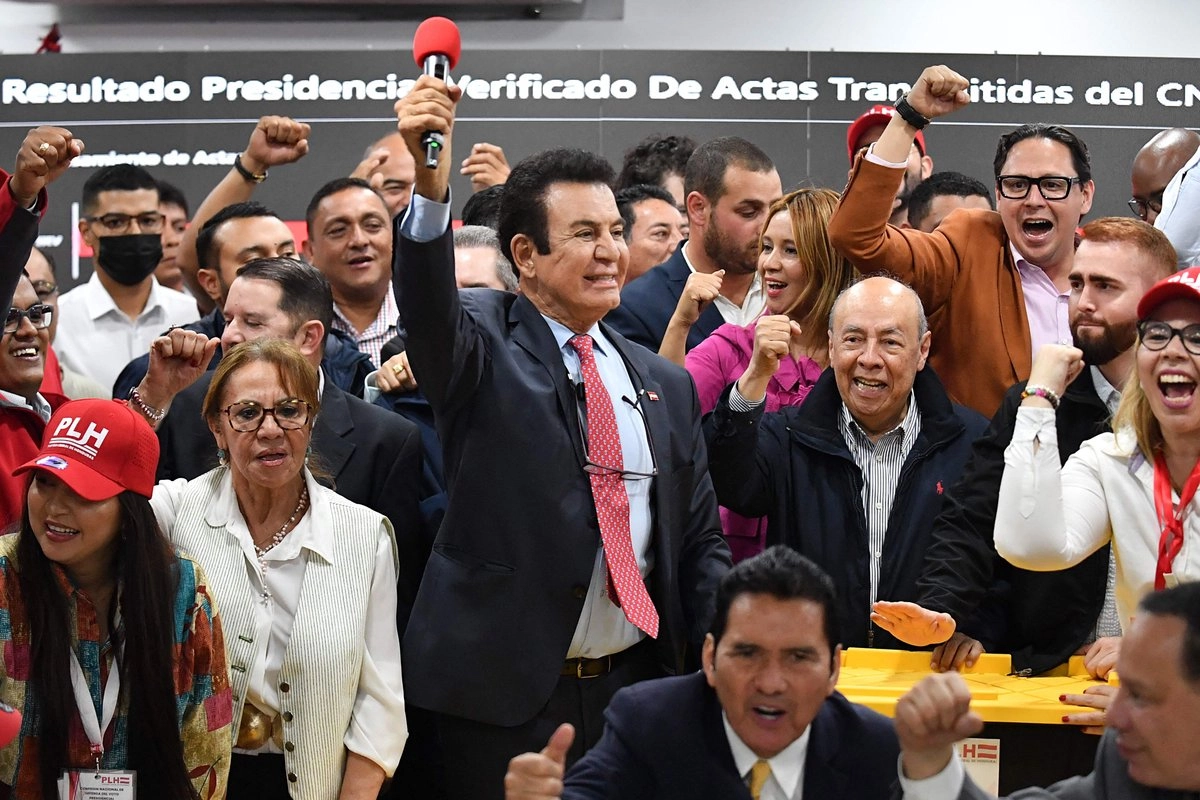Salvador Nasralla (C), candidato presidencial del opositor Partido Liberal, celebra con sus principales colaboradores junto a las cajas con actas electorales durante una conferencia de prensa en Tegucigalpa el 2 de diciembre de 2025. 