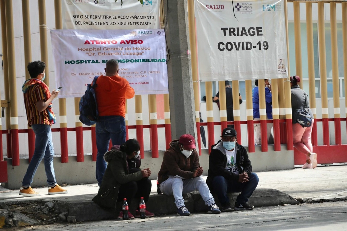 Familiares observan un aviso colocado sobre la entrada al área de urgencias del Hospital General de México, que indica que el nosocomio no tiene disponibilidad para atender pacientes con Covid-19, en la Ciudad de México, el 18 de agosto de 2021. Foto Luis Castillo