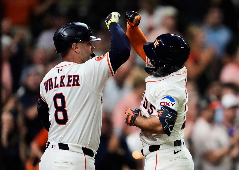 El jardinero izquierdo de los Astros de Houston, José Altuve (27), celebra con Christian Walker (8) tras conectar un jonrón durante la quinta entrada de un partido de béisbol contra los Marineros de Seattle. Foto