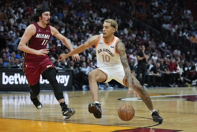 El jugador de los San Antonio Spurs, Jeremy Sochan (c,der), regatea por la cancha perseguido por el guardia del Miami Heat, Jaime Jaquez Jr (izq). Foto Ap