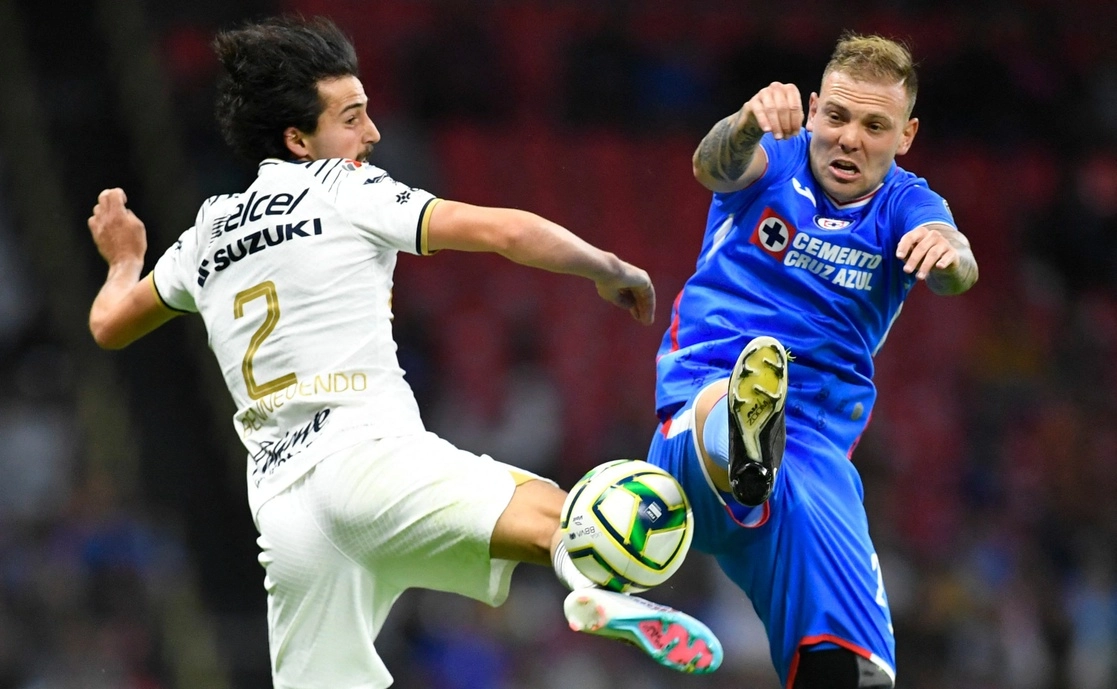 Carlos Rotondi(der.) disputa el balón con Pablo Bennevendo(izq.), durante el partido entre Cruz Azul y Pumas de la fecha 11 de la Liga Mx. Foto Afp.