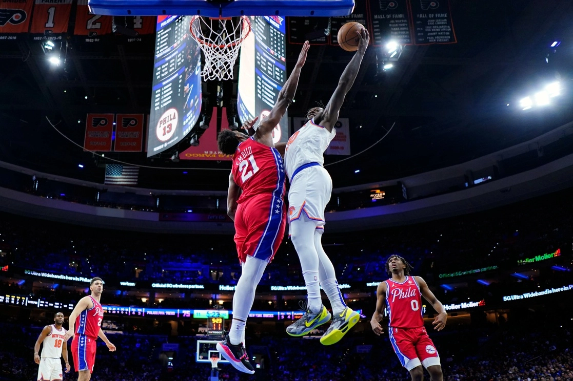 Julius Randle, derecha, y Joel Embiid en una de las jugadas del encuentro. Foto Ap