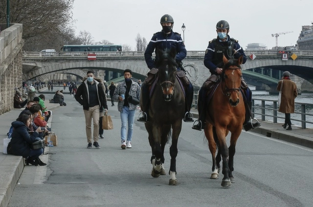 Miembros de la Policía Montada patrullan a lo largo del Río Sena, en París. Foto Ap