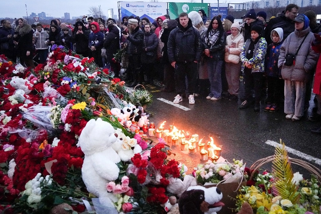 Personas dejan flores y encienden velas en el ayuntamiento de Crocus, en Moscú, Rusia. Foto Ap 