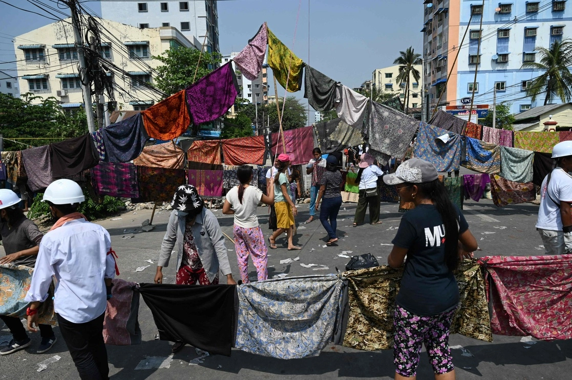 Manifestantes birmanos colocan ‘longyis’ en las calles para detener momentáneamente a la policías en caso de represión. Foto Afp