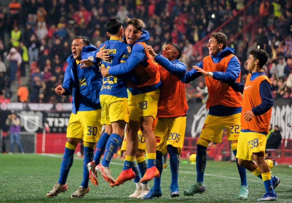 Los jugadores del América abrazan a Slavador Reyes, que marcó los dos goles del triunfo de las Águilas sobre Xolos de Tijuana en la fecha inaugural del torneo Clausura 2024 de la Liga Mx. Foto Afp.