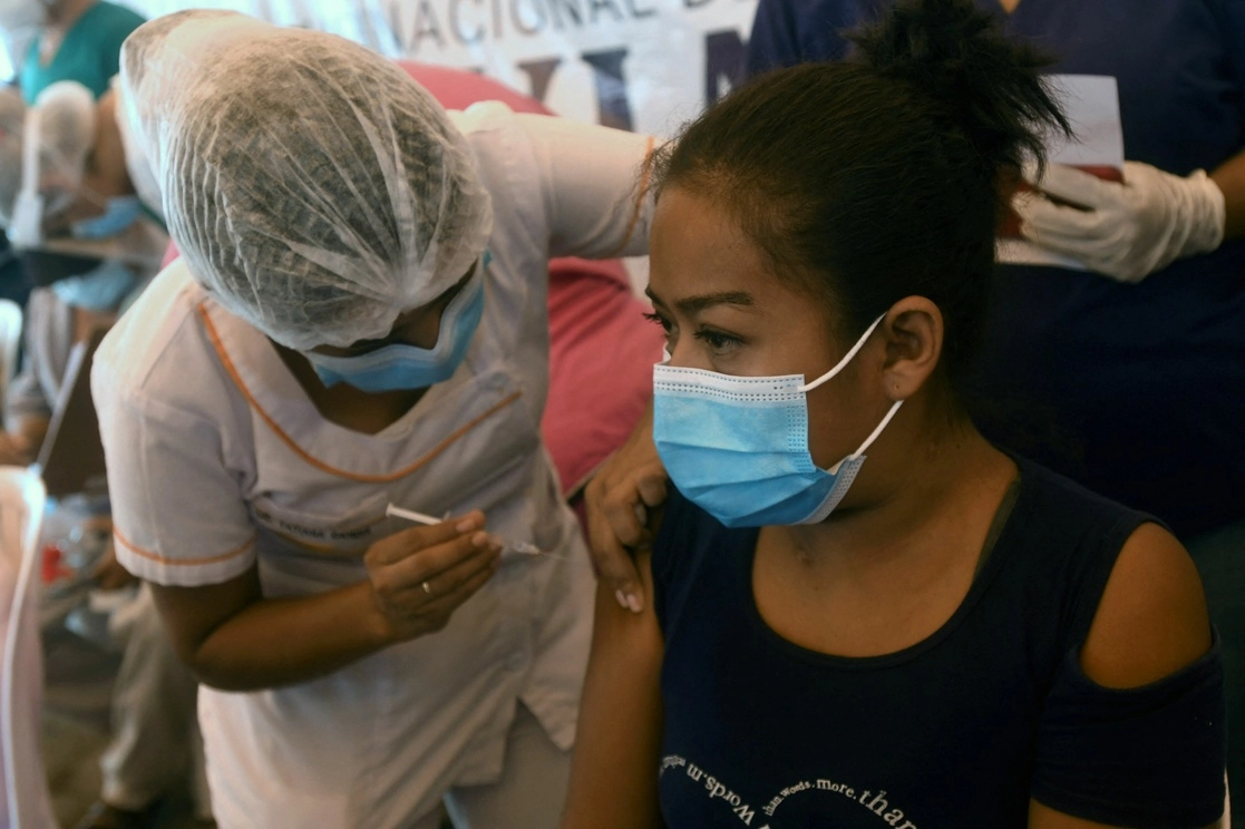 Una mujer con enfermedades preexistentes es vacunada contra el Covid-19 con el biológico de Sinopharm, en Santa Cruz, Bolivia, el 25 de febrero de 2021. Foto Str vía Afp 