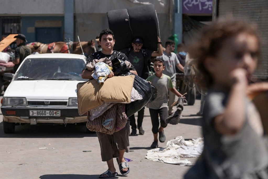 Palestinos abandonan escuela que usaban como refugio en Deir al-Balah, en la franja de Gaza. Foto Ap 